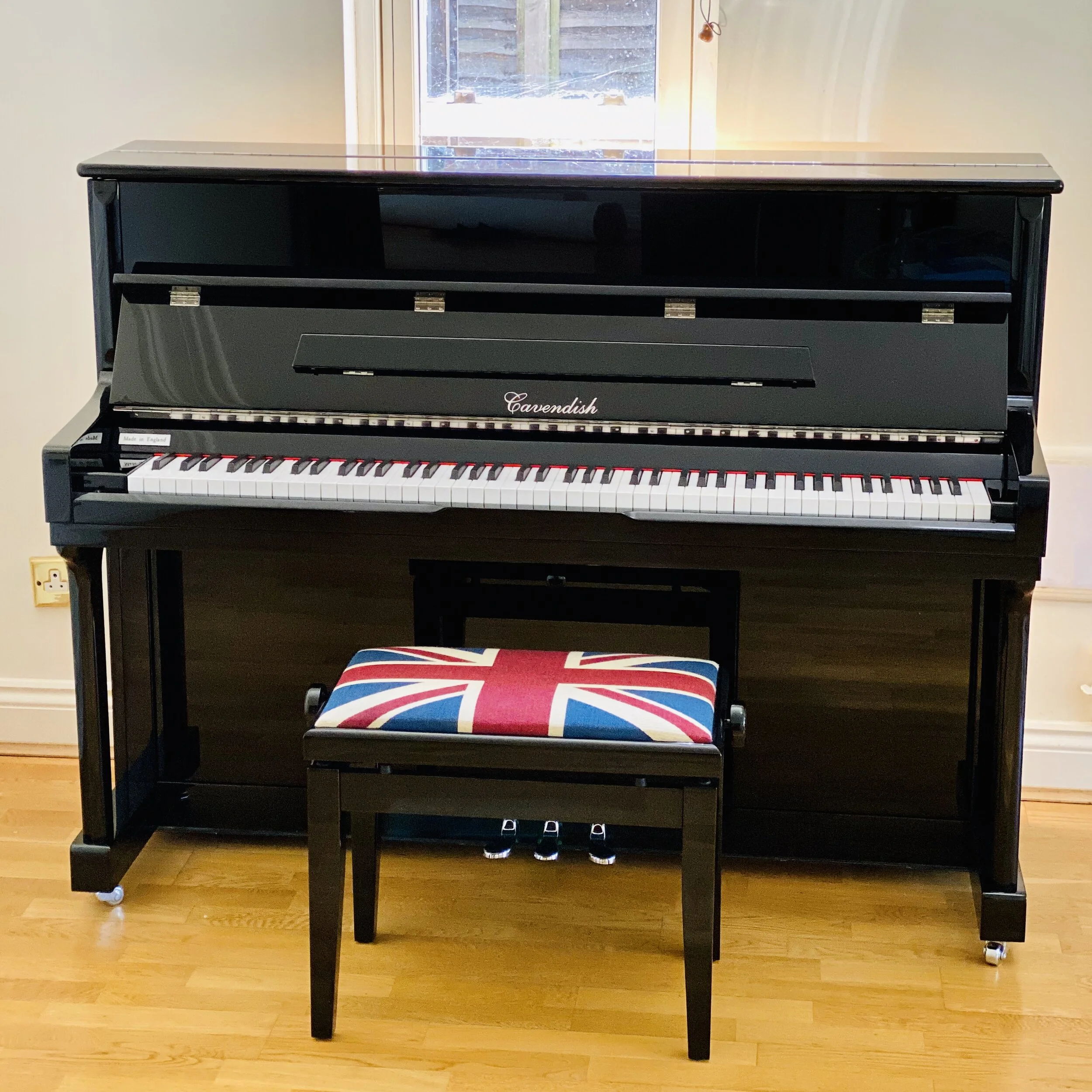 Upright piano wrapped in a fitted transit cover ready to move in Wimbledon